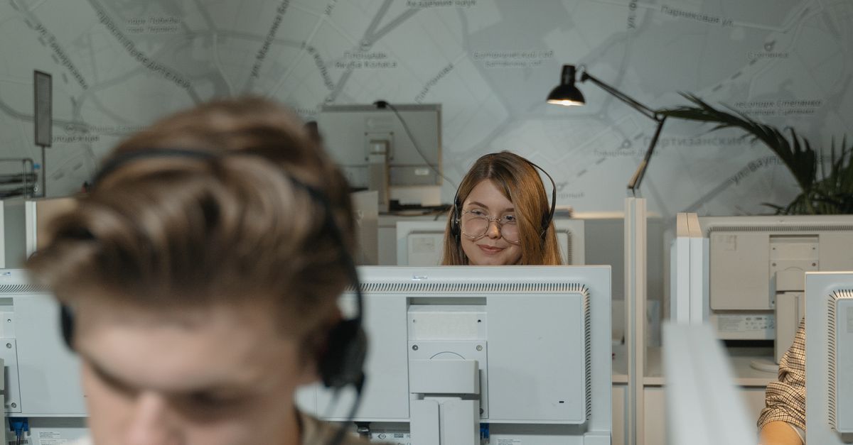 Call center employees working with computers and headsets, providing customer support.