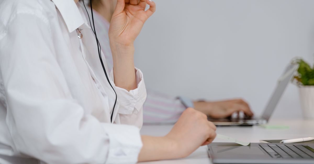 A focused call center professional using a headset at work in an office setting.
