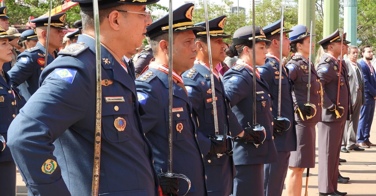 Uniformed officers holding swords during a formal military ceremony in Mato Grosso, Brazil.