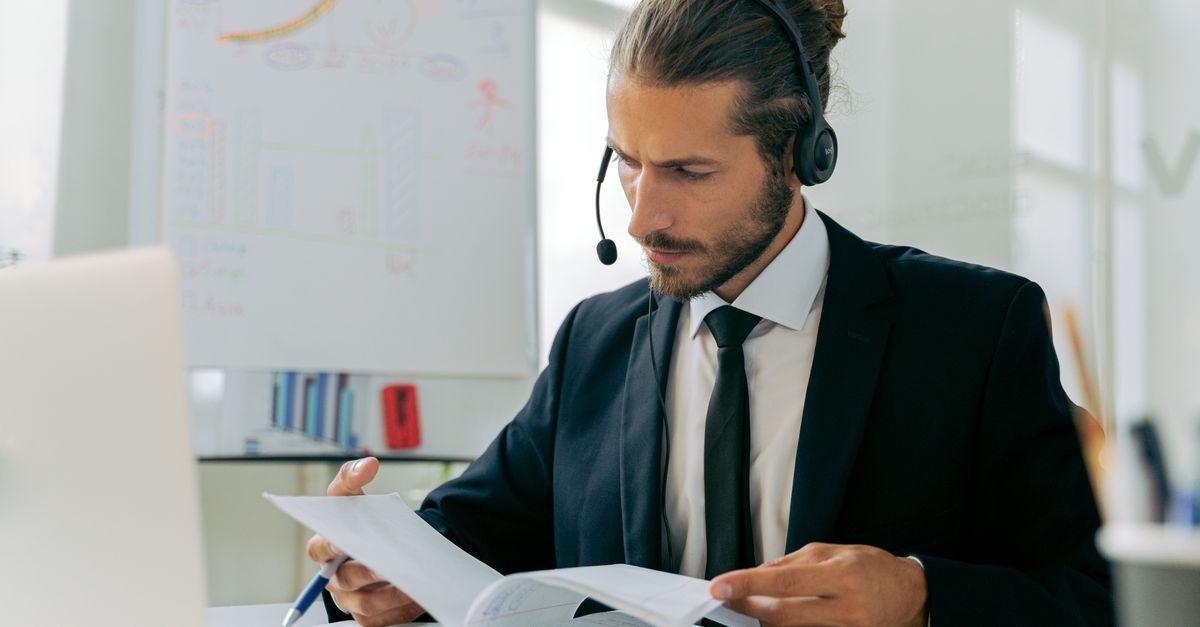Focused business professional handling customer service tasks with a headset in an office setting.