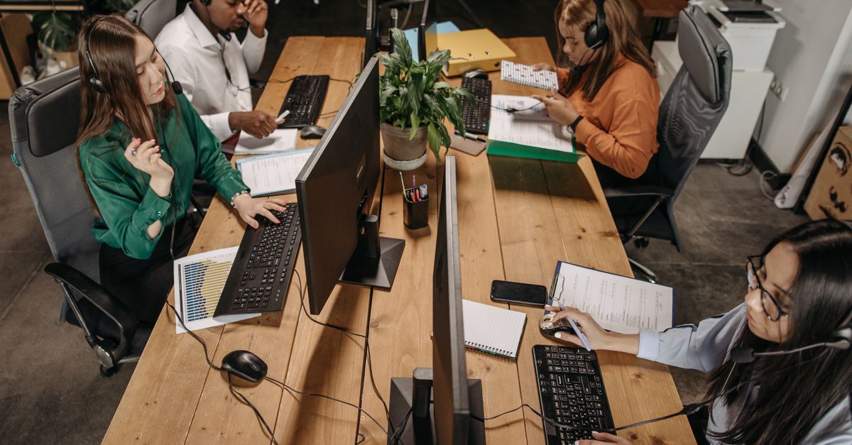 Diverse team of customer service representatives working collaboratively in a modern office environment.