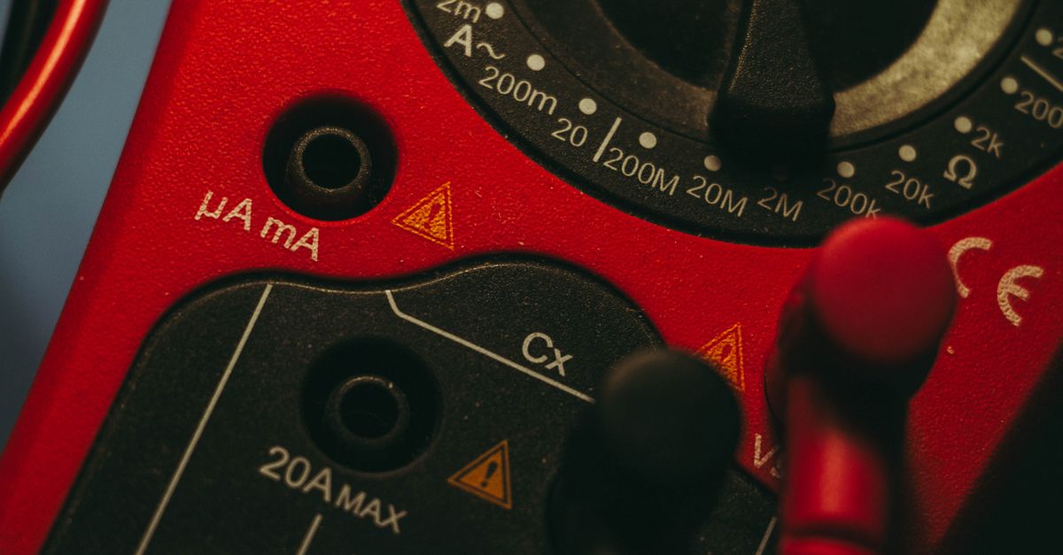 Detailed image of a red multimeter, showcasing measurement dial and connectors, ideal for tech enthusiasts.