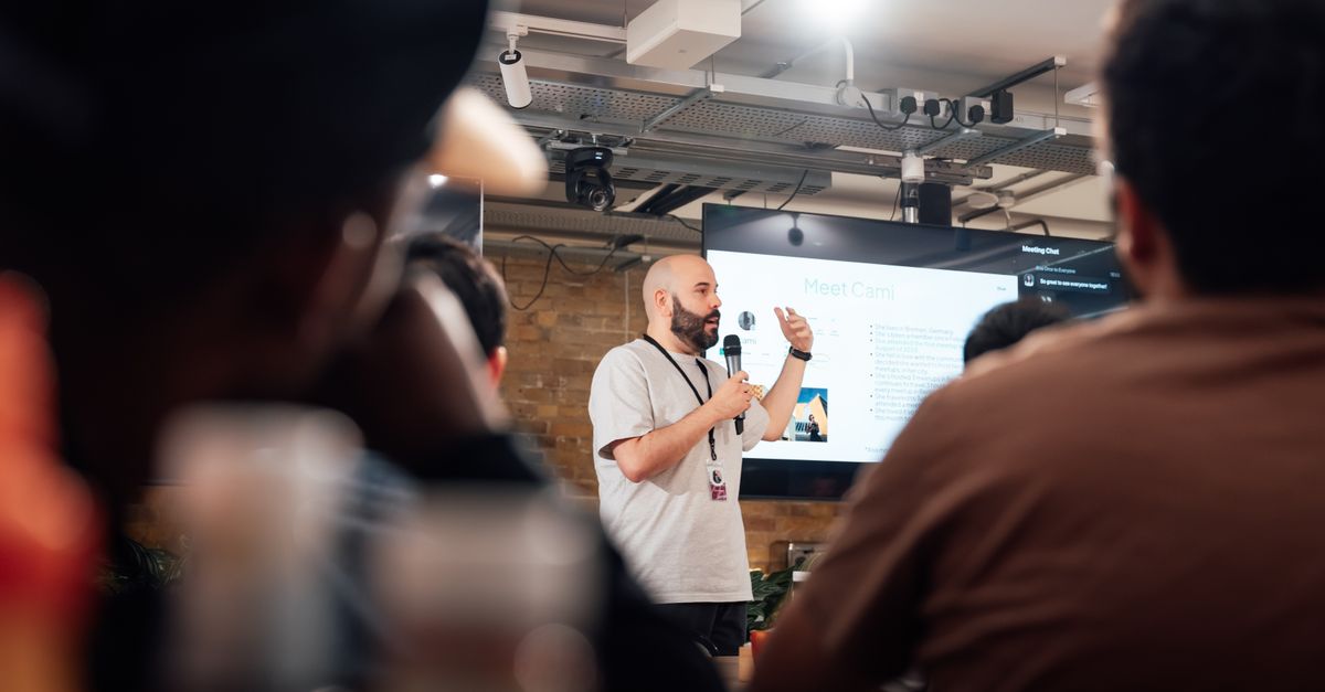 Engaging speaker presenting to an attentive audience during a tech event in London.