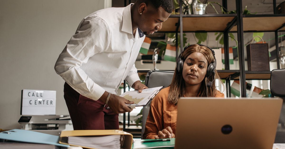 Call center employees collaborating with modern technology, promoting teamwork and efficiency.